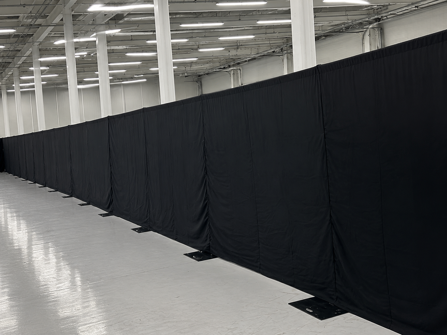 Black wool serge drapes hung along a wall